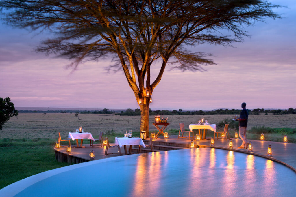 Luxury safari pool surrounded by glowing lanterns at sunset – Complete Guide to African Safaris.
